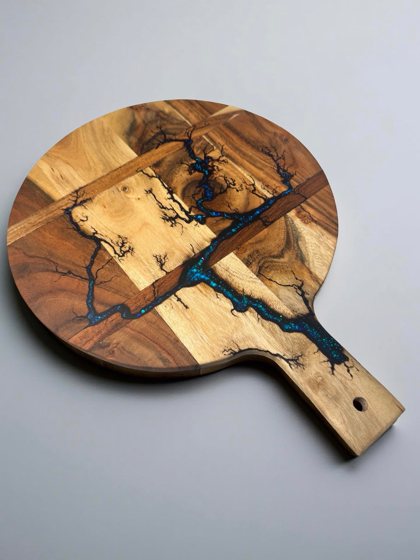 Fractal burned acacia cheese board with vibrant blue sparkle resin flowing through the timber grain, handcrafted resin board East Gippsland Australia, Fractal Flow Designs