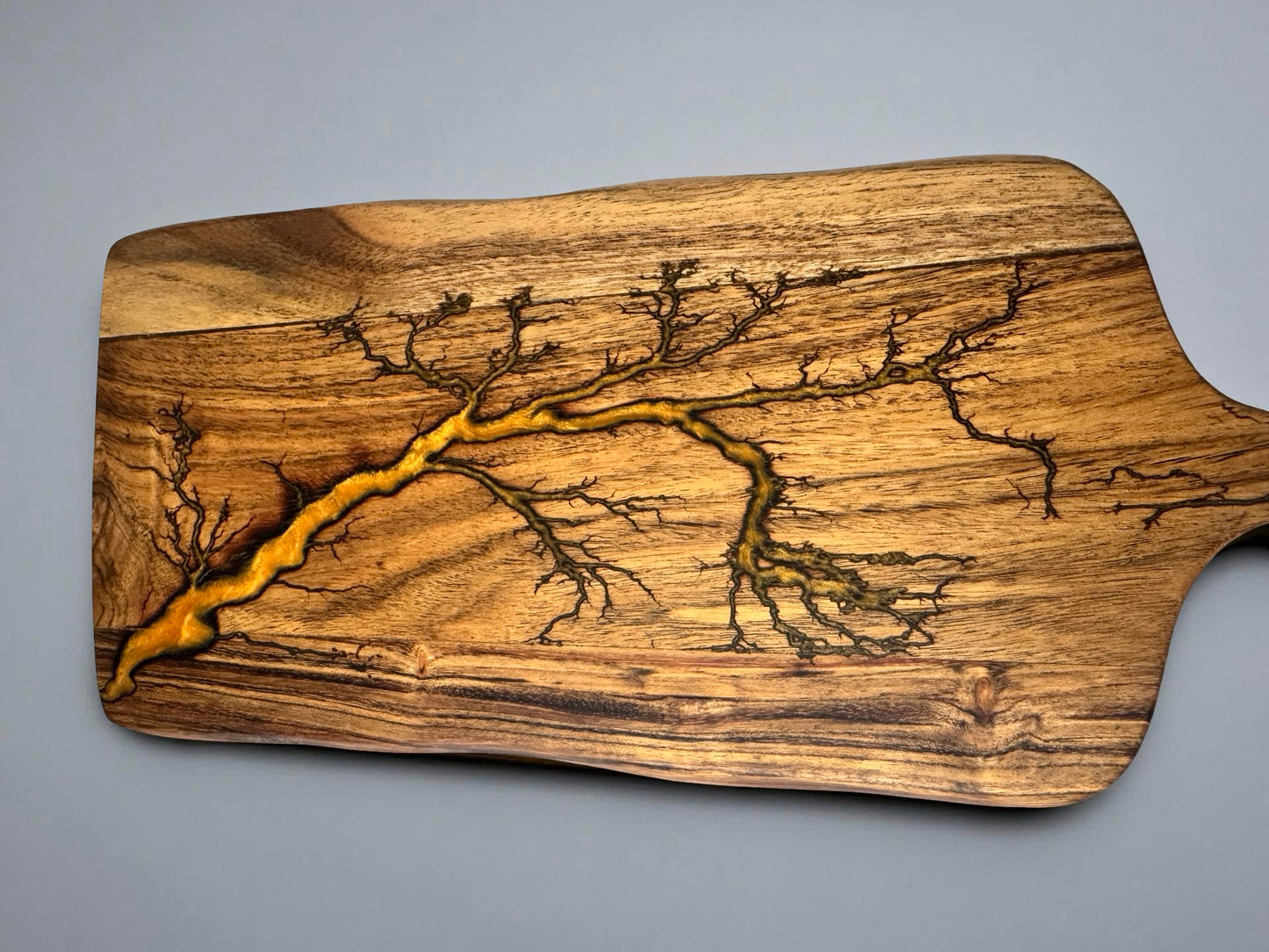 Acacia timber paddle cheese board with vibrant orange resin inlay and fractal burn lightning artwork, handmade Australian resin board East Gippsland, Fractal Flow Designs